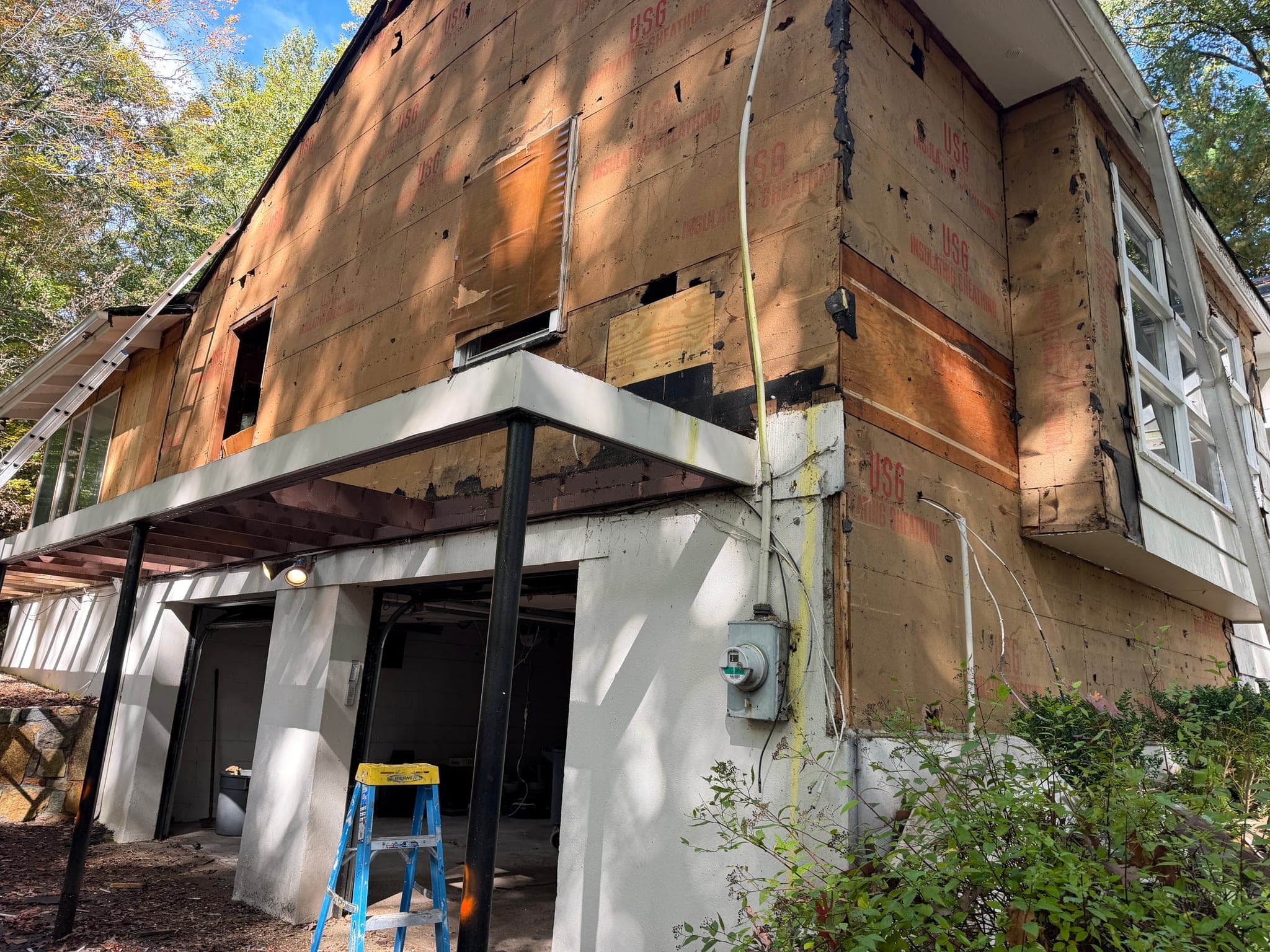 65 Windmill Road: Sheathing exposed above the lower-level garage, beneath the deck