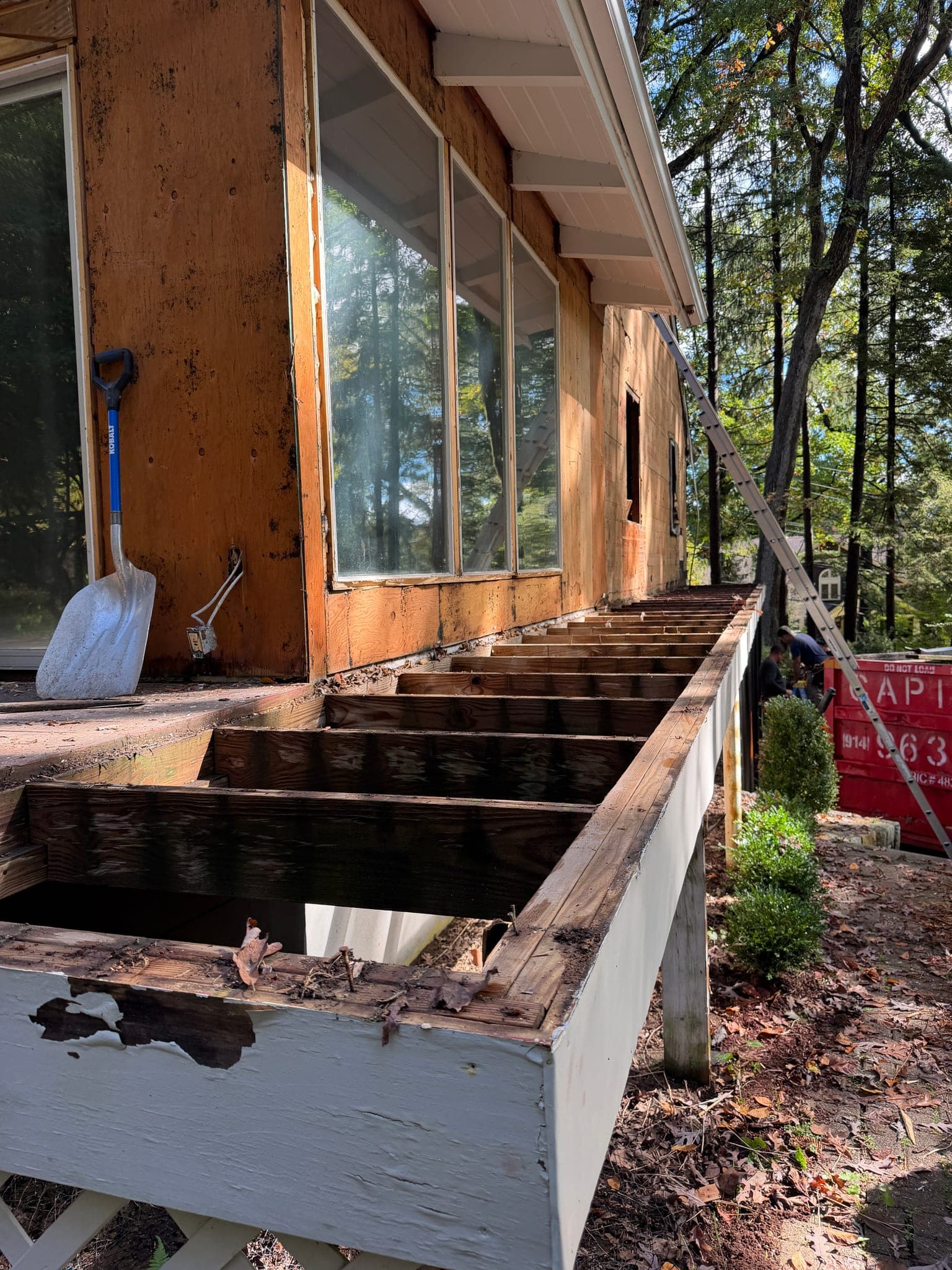 65 Windmill Road: The deck taken down to its joists along the wall of glass