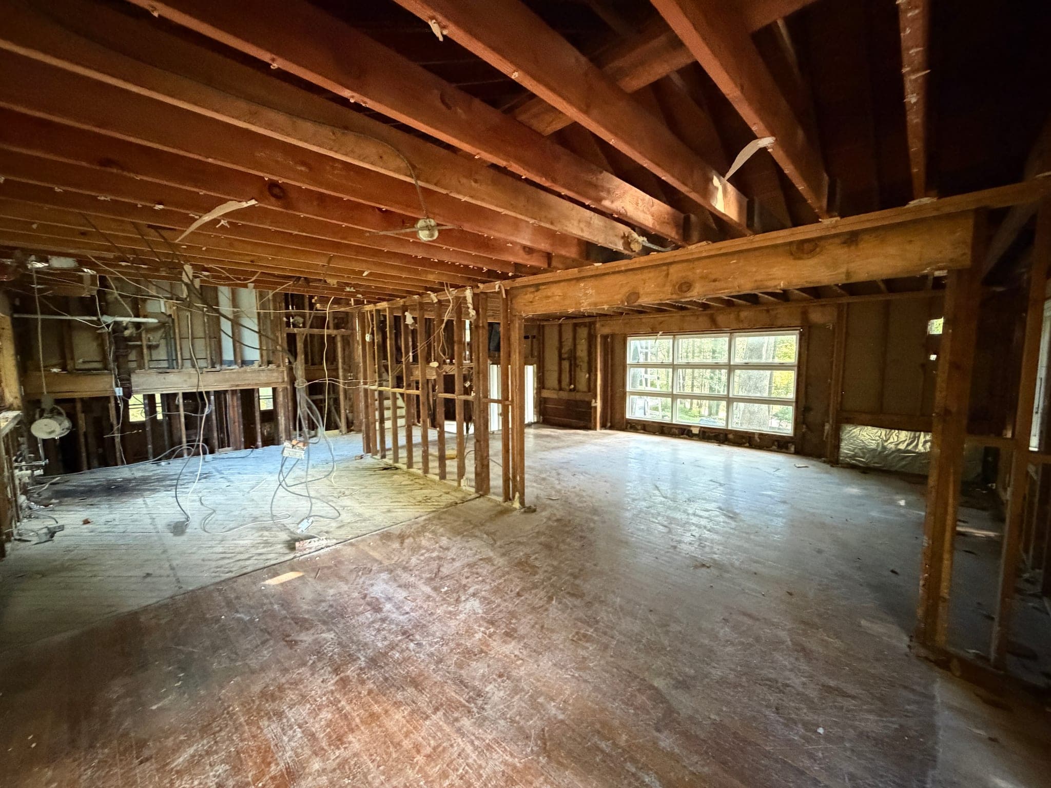 65 Windmill Road: Ceiling joists and stud walls exposed across the main level